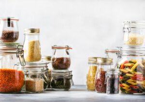 cereals, legumes, pasta and lentils in an array of glass jars