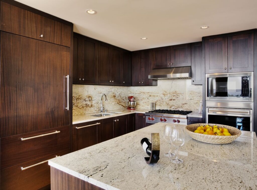 luxury kitchen with dark wood cabinets and quartz countertops and backsplash